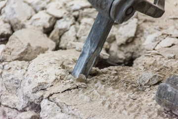 Trabalho árduo de demolição de estrutura de concreto com ferramenta.