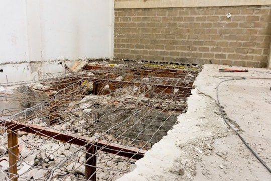 Demoli&ccedil;&atilde;o de estrutura de concreto com entulhos e res&iacute;duos a serem coletados.