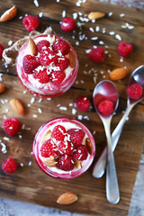 Selective focus. Healthy dessert in jars with curd cream and raspberries.