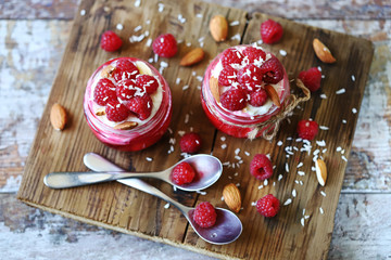 Selective focus. Healthy dessert in jars with curd cream and raspberries.