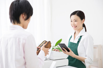 Fototapeta premium 会計をする女性店員