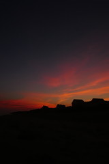 Summer sunset with orange skies and beach front homes in the horizon