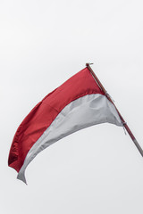 Indonesian flag waving with cloudy sky background