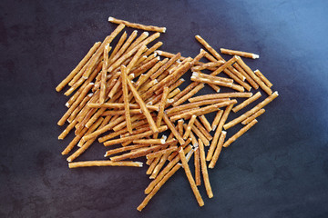 High angle view of a pile of pretzel sticks on a dark background