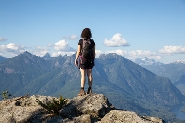 Fototapeta premium Adventurous Girl Hiking on top of Tin Hat Mountain, part of the popular Sunshine Coast Hiking Trail in Powell River, British Columbia, Canada. Concept: Explore, Adventure, Travel