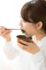 味噌汁を食べる女性