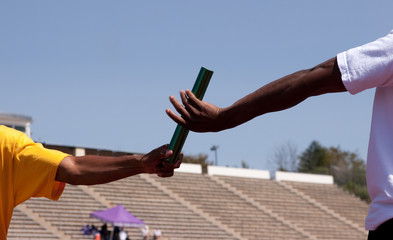 Two athletes practice baton pass