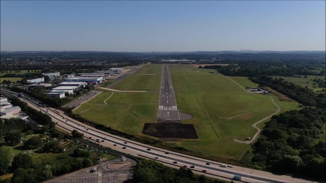 Airport Runway aerial drone shot. UK flights, transportation. COVID-19 means lack of flights, quiet. Flybe job losses. M27 Motorway. Zoom shot