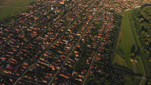 Aerial pan up high above the small town of Novi Becej in Serbia at golden hour.
