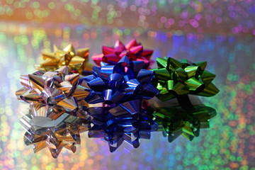 Festive colorful abstract of gift bows on a mirror with multicolor bokeh background