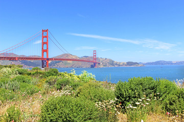 Golden Gate bridge in San Francisco, the view on the blue ocean and green bushes and flowers on a beautiful sunny summer day