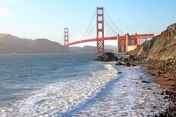 Crédence de cuisine en verre imprimé Plage de Baker, San Francisco The view on the Golden Gate bridge from San Francisco Baker beach bay. Beautiful sea scenery with white waves crashing to the rocks on the sandy shore. 