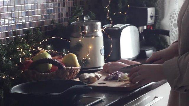 Woman cuts garlic for cooking chicken
