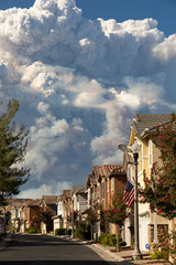 Californian seasonal fire with high smoke cloud in suburban neighborhood