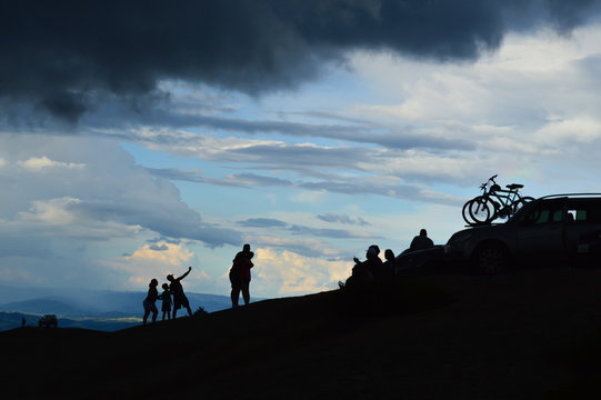 silhouette of a cyclist a couple and a litlle family over the pedra grande atibaia
