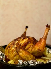 Fried chicken in the oven with vegetables. Defocus light background.