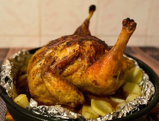 Fried chicken in the oven with vegetables. Defocus light background.