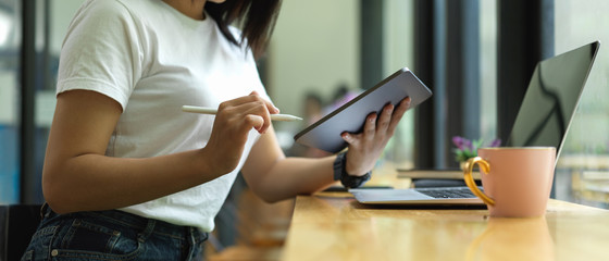 University student doing assignment with digital devices on counter bar in cafeteria