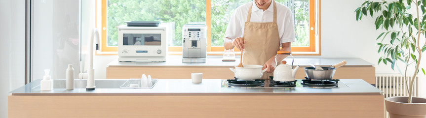 キッチンで料理する若い男性