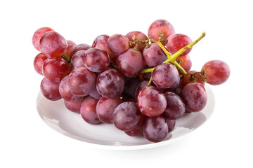 Close-up red ripe grape on the white dish, it is a sweet and juicy fruit.