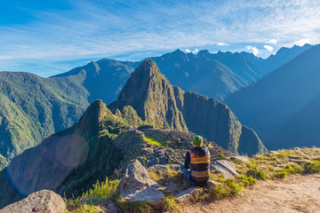 Tourist contemplating the Machu Picchu inca ruin at sunrise, Cusco, Peru.