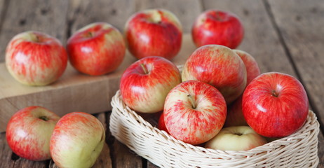 Agricultural apple background. Red early ripe apples on a wooden background.