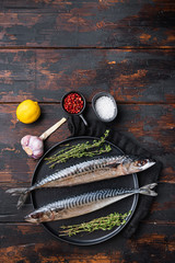 Whole mackerel with ingredients on wooden table, top view with copy space
