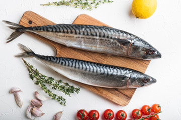 Two whole mackerel with ingredients on white textured background, flat lay