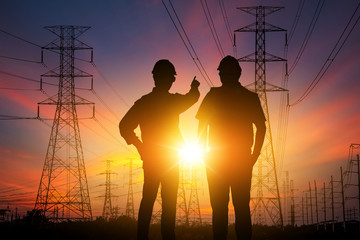 Silhouette Teams engineer looking High voltage electric tower on sunset time and sky on sunset time 