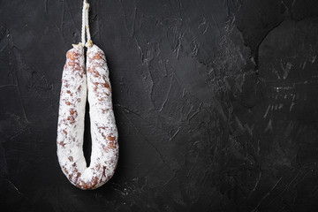 Fuet salami  wurst on black textured background with copy space