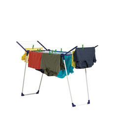 Clean clothes hanging on dryer against white background