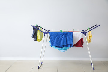 Clean clothes hanging on dryer indoors