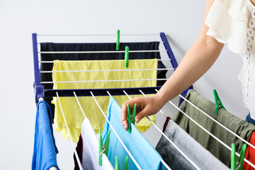 Woman hanging clean clothes on dryer, closeup