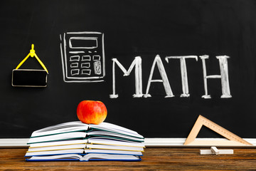 Stationery and apple on table in classroom