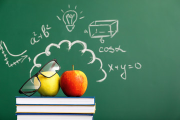 Creative composition with books, apples and school blackboard