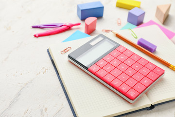 Set of school stationery and calculator on light background