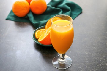 Glass of fresh orange juice on table