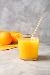 Glass of fresh orange juice on table