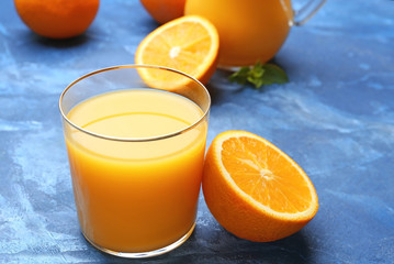 Glass of fresh orange juice on table
