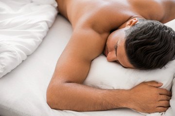 Obraz na płótnie Canvas Handsome naked man sleeping in bed