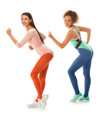 Young women doing aerobics on white background