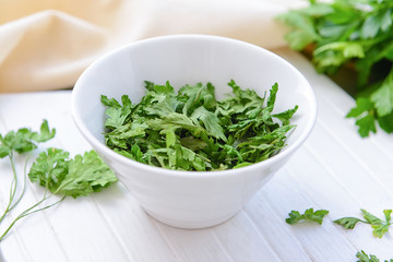 Bowl with dry parsley on table