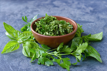 Bowl with dry parsley on dark background
