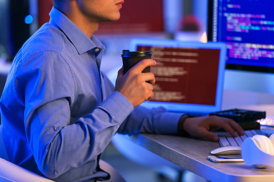 Male programmer working in office at night
