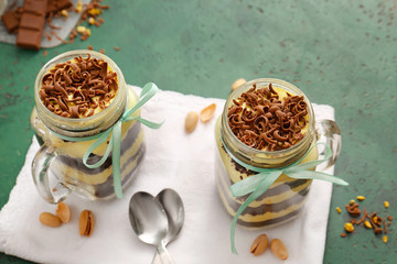 Delicious cupcakes in jars on color background