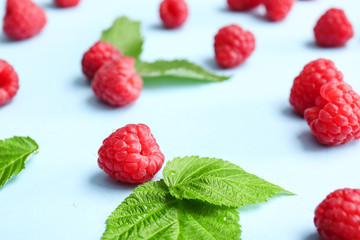 Tasty ripe raspberries on color background