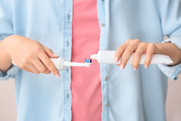 Woman with electric toothbrush and paste, closeup