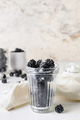 Fototapeta na wymiar Glass with tasty blackberry on white background
