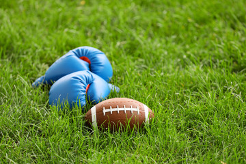 Rugby ball with boxing gloves outdoors