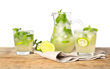 Glassware of fresh mojito on table against white background